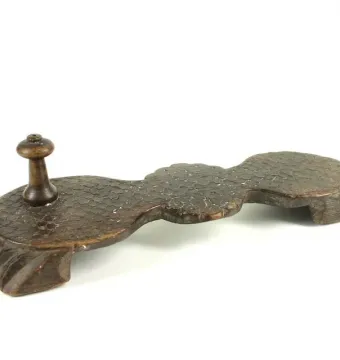 Paduka wooden sandal with a curved base and carved feet support.