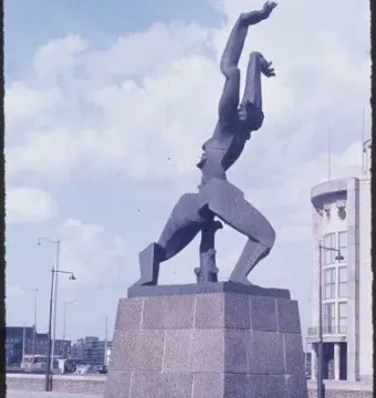 The Destroyed City sculpture by Ossip Zadkine in an open plaza, showing a dark figure with raised arms and a jagged void in its torso.