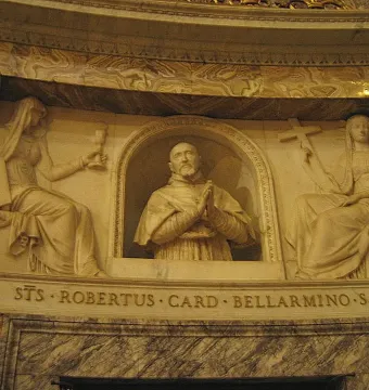 Marble relief of Cardinal Roberto Bellarmine in a niche, flanked by seated female figures holding a chalice and a cross.