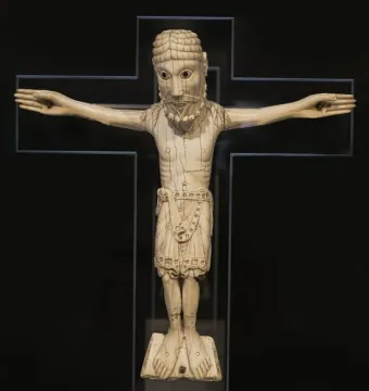 Carrizo Christ crucifix sculpture with a light-colored figure, dark cross, large eyes, beard, and decorative loincloth