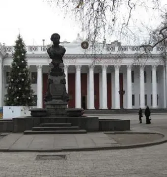 Pushkin bust on a tall ornate pedestal in a paved plaza