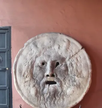 Bocca della Verità stone mask with a bearded face and open mouth on a pedestal
