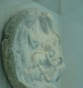 Taddei Tondo marble relief with a seated woman, an infant, and a standing youth.