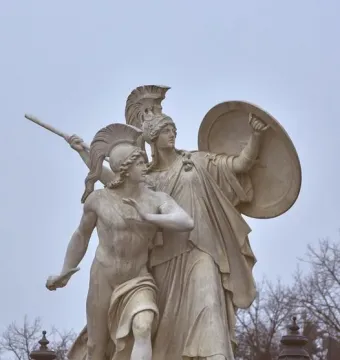 Athena Protects the Young Hero stone sculpture showing a helmeted goddess with shield and spear behind a young hero.
