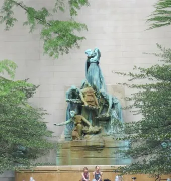The Fountain of the Great Lakes sculpture with five female figures, water jets, and two bicycles nearby.