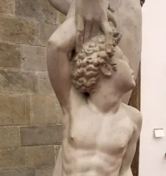 Apollo and Hyacinth marble sculpture showing a kneeling nude male figure looking upward as a taller figure reaches down to grasp his hair