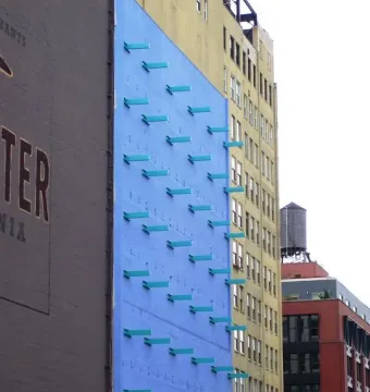 The Wall with a blue facade and turquoise rectangular protrusions arranged in diagonal rows.