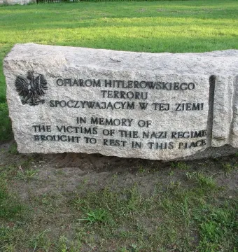 Monument of Common Martyrdom stone memorial with engraved Polish and English text and a metal eagle emblem.