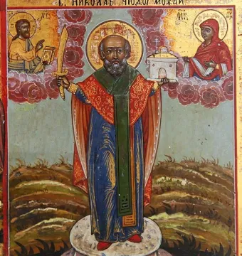 Saint Nicholas of Mozhaysk standing in ornate robes, holding a sword and a small church model.