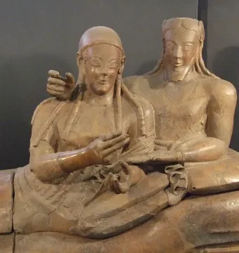 Sarcophagus of the Spouses showing a reclining Etruscan man and woman with gentle smiles and outstretched hands.