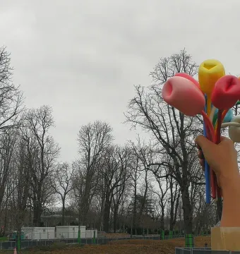 Bouquet of Tulips sculpture showing a giant hand holding oversized colorful tulips outdoors under an overcast sky.