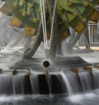 Hornsby Water Clock with central jets of water and large green wheel-like elements.
