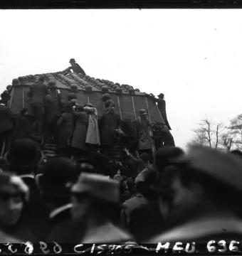 The Marly Horses covered with helmets, with people climbing on the monument and a crowd watching below.