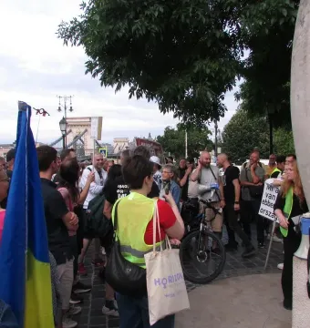 Zero Kilometre Stone partially visible with the carved letters KM and a megaphone leaning against it.