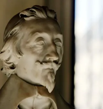 Bust of Cardinal Richelieu in white marble, with curly hair, a mustache, and a pointed beard.
