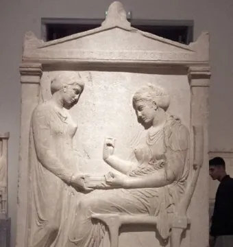 Grave Stele of Hegeso showing two draped women, one seated and examining an object while another stands beside her with an open box.