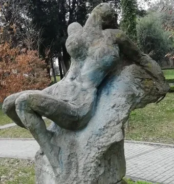 Güzel İstanbul, a weathered stone sculpture of a reclining figure outdoors near a walkway.