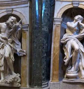 Saints Jerome and Mary Magdalen marble statues in arched niches with dark columns, showing Jerome holding a cross and Magdalen gazing upward.