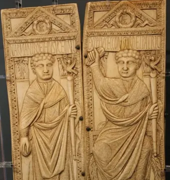Diptych of Boethius with two carved ivory panels showing standing male figures in robes holding staffs topped with birds.