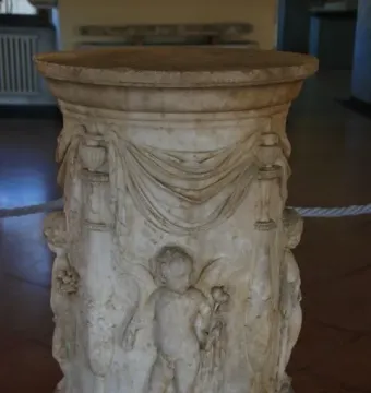 Four Seasons Altar with carved marble reliefs, draped swags, and putti holding flowers and grapes.