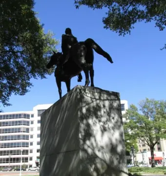 Bernardo de Gálvez bronze equestrian statue seen from behind on a stone pedestal.