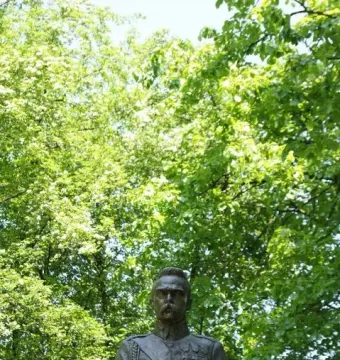 Bronze bust of Józef Piłsudski in military uniform on a rough stone pedestal.