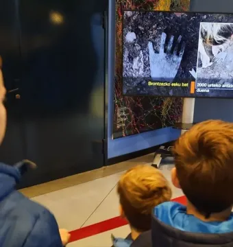 The Hand of Irulegi shown on a digital screen alongside an image of an excavation scene.