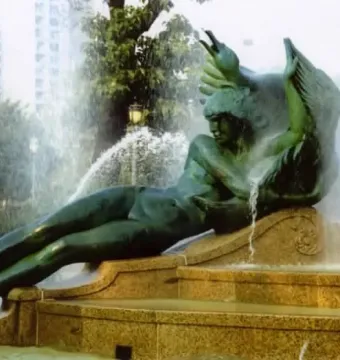 Swann Memorial Fountain with a winged reclining bronze figure spraying water from the multi-tiered basin.