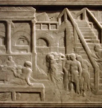 The Feast of Herod relief showing figures gathered around a table beside a dancing figure in an arched architectural setting.