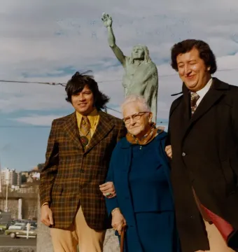 Chief Seattle statue with three people posing in front of it