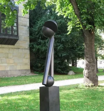Große zwei V, a dark abstract bronze sculpture with two angled columns and a split spherical top outdoors.