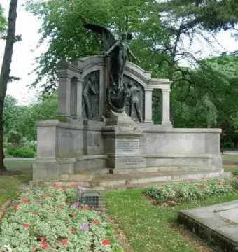 Titanic Engineers\' Memorial with a winged bronze figure holding a wreath on a ship-like stone base in a park.