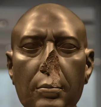Berlin Green Head, a dark greenish-grey stone head with a damaged nose and broken neck.