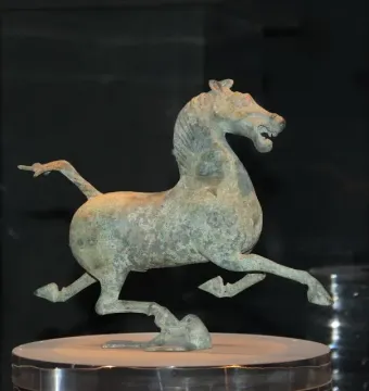 Flying Horse of Gansu bronze horse statue in a galloping pose, balancing on one hoof atop a bird-like figure.