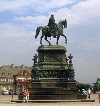 King Johann Memorial bronze equestrian statue on an ornate pedestal in a public square.
