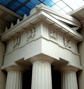 Parthenon metopes with marble relief figures in a battle scene beneath a glass ceiling.