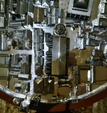 Gioiello di Vicenza shown as a circular miniature architectural model with many small metallic buildings and structures.