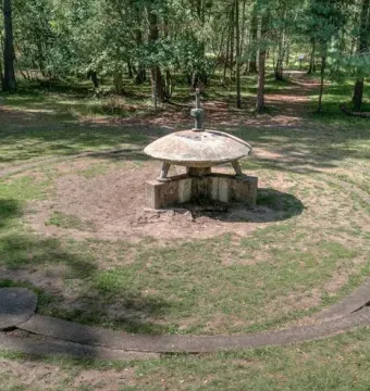 UFO Memorial concrete sculpture with a stylized flying saucer form and circular ring in a grassy clearing