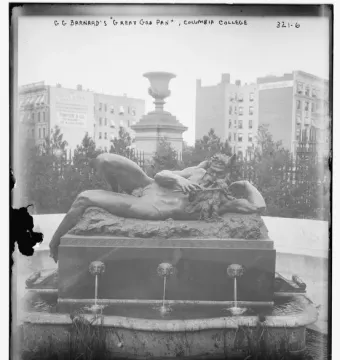 The Great God Pan reclining on a fountain pedestal with lion-head spouts and a tiered pool below.