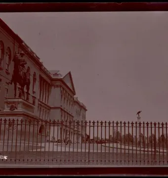 Equestrian statue of General Joseph Hooker in front of a classical building and iron fence.
