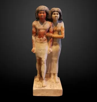 Raherka and Meresankh limestone statue showing a standing Egyptian man and woman together on a base.