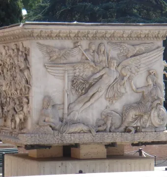 The marble base of the Antoninus Pius Column with detailed relief scenes, including a winged apotheosis panel and a procession of figures.