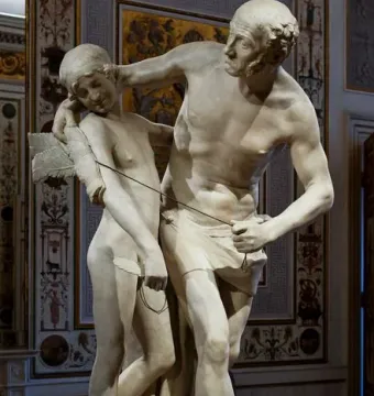 Daedalus and Icarus marble sculpture showing an older bearded man embracing a winged nude youth while fastening the wings with cords.