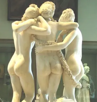 The Three Graces marble sculpture seen from behind, with three intertwined figures on a museum base.