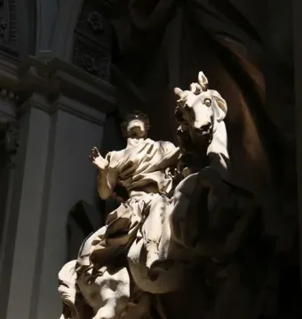 The Vision of Constantine marble statue of a man on a rearing horse, lit by a dramatic shaft of light.