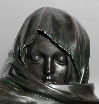 Close-up of the Winter sculpture’s head with closed eyes and a tightly draped head covering.