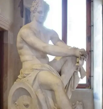Ludovisi Ares seated with a shield beside him and a small winged figure near his leg.