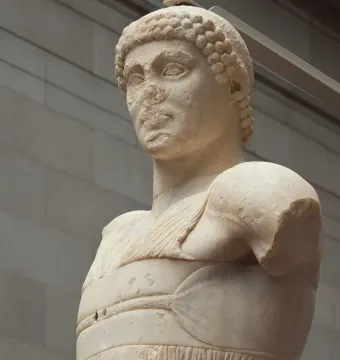 Motya Charioteer marble sculpture showing a worn head, draped torso, and missing arms.