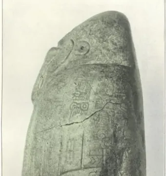 Right side of the Tuxtla Statuette showing a carved bird-like head and inscribed stone surface with a diagonal crack.