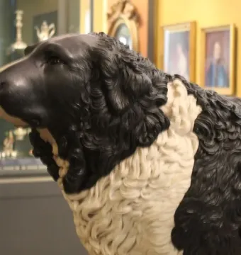 Close-up of the Bashaw dog sculpture with a textured black-and-white surface and raised head turned left.